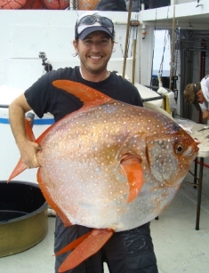 Southwest Fisheries Science Center biologist Nick Wegner holds a captured opah, the first-ever warm-blooded fish